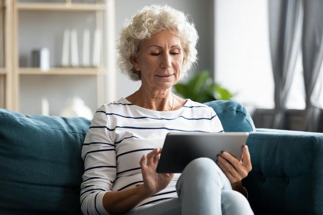 Member using a tablet on a couch