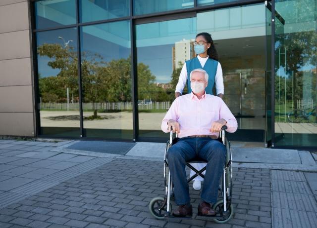 Caregiver assisting a man in a wheelchair